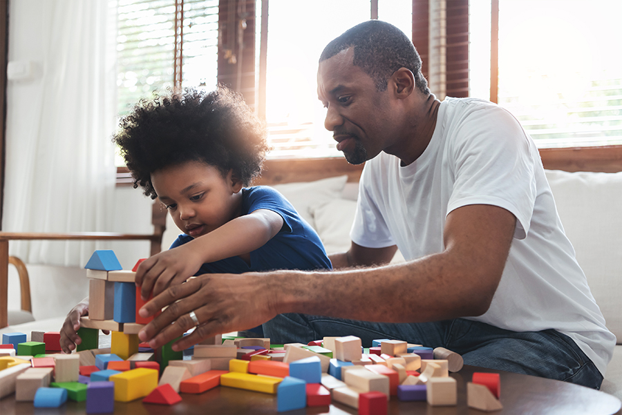 father and child building with wooden blocks, together